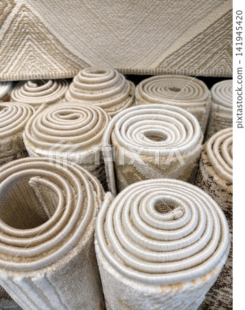 Soft luxurious carpets rolled into display rolls in a hypermarket presenting organized arrangement and attractive textures Soft luxurious carpets rolled into display rolls in a hypermarket presenting organized arrangement and attractive textures 141945420