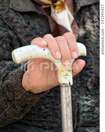 Old woman hand holding a walking cane emphasizing careful movement physical support and safe mobility in later life Old woman hand holding a walking cane emphasizing careful movement physical support and safe mobility in later life 141945427