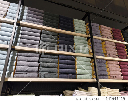 Assorted multicolored towels placed neatly on spacious shelves in home supply market Assorted multicolored towels placed neatly on spacious shelves in home supply market 141945429