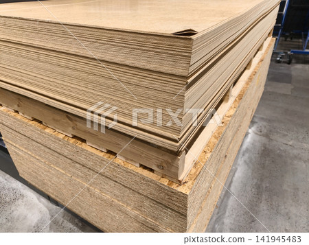 Fiberboards and Oriented Strand Boards or OSB, large stacks of building materials and other wood product placed in industrial warehouse 141945483