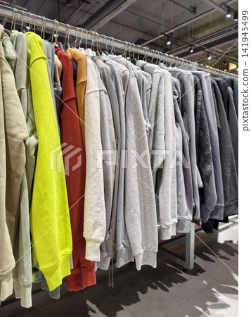 Bright sports jackets hanging in an organized row inside a shop create a visually appealing presentation of functional apparel for customers Bright sports jackets hanging in an organized row inside a shop create a visually appealing presentation of functional apparel for customers 141945499
