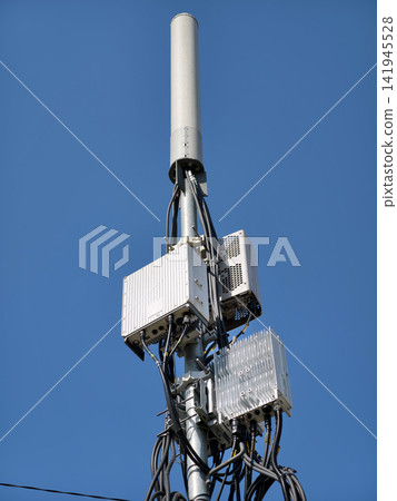 Modern 5G cell tower standing against a clear blue sky Modern 5G cell tower standing against a clear blue sky 141945528