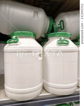 White plastic barrels with green lids arranged carefully on shelves of a home improvement store, perfect for any project White plastic barrels with green lids arranged carefully on shelves of a home improvement store, perfect for any project 141945552