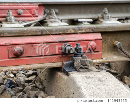 Red rail clamp holds rails in place preventing movement under train load Red rail clamp holds rails in place preventing movement under train load 141945555