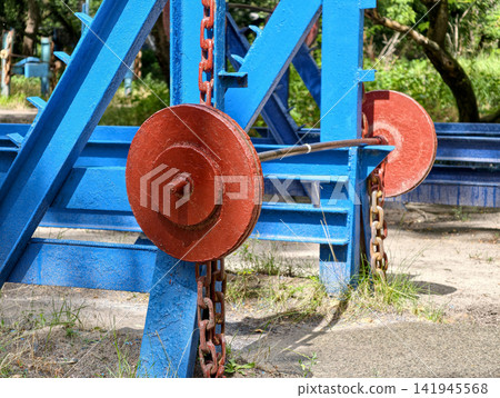 Large heavy barbell with bright red plates standing on an outdoor fitness area as traditional equipment for weightlifting and muscle development Large heavy barbell with bright red plates standing on an outdoor fitness area as traditional equipment for weightlifting and muscle development 141945568