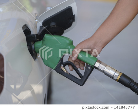 Pumping gas at gas pump. Closeup of man pumping gasoline fuel in car at gas station Pumping gas at gas pump. Closeup of man pumping gasoline fuel in car at gas station 141945777