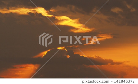 Solar Eclipse, Red Sky and Dramatic Clouds at Sunset Solar Eclipse, Red Sky and Dramatic Clouds at Sunset 141946372