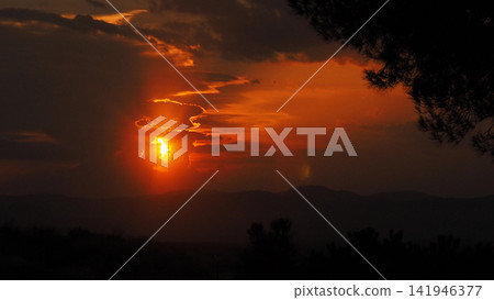 Solar Eclipse, Red Sky and Dramatic Clouds at Sunset Solar Eclipse, Red Sky and Dramatic Clouds at Sunset 141946377