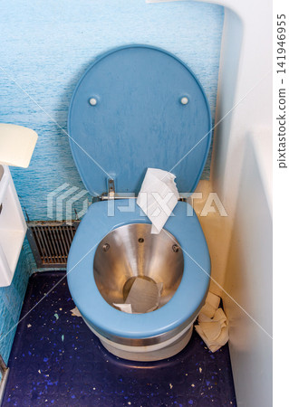 Overhead view of an open toilet with a blue seat and stainless-steel bowl inside a compact train lavatory Overhead view of an open toilet with a blue seat and stainless-steel bowl inside a compact train lavatory 141946955
