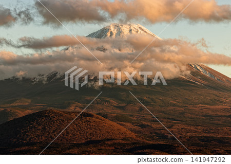 Mount Fuji at sunset, with clouds gathering, as seen from the Shojiko Lake Panorama Platform. Mount Fuji at sunset, with clouds gathering, as seen from the Shojiko Lake Panorama Platform. 141947292