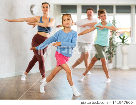 Parents with young daughter and schoolboy son are taught to move to boogie-woogie Parents with young daughter and schoolboy son are taught to move to boogie-woogie 141947600