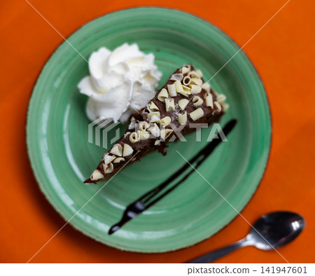 Piece of chocolate cake with chocolate topping 141947601