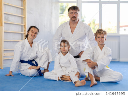 Family of karatekas posing on floor in studio Family of karatekas posing on floor in studio 141947695