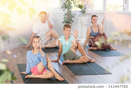 Family with two children doing yoga in studio Family with two children doing yoga in studio 141947760