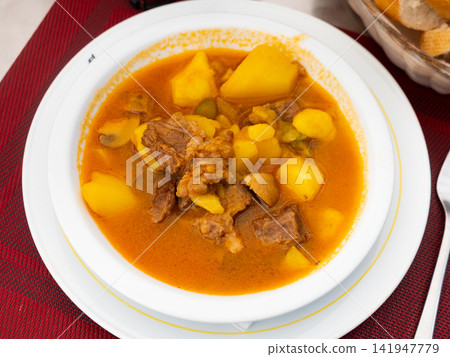 Veal meat stewed in gravy with potato and vegetables Veal meat stewed in gravy with potato and vegetables 141947779