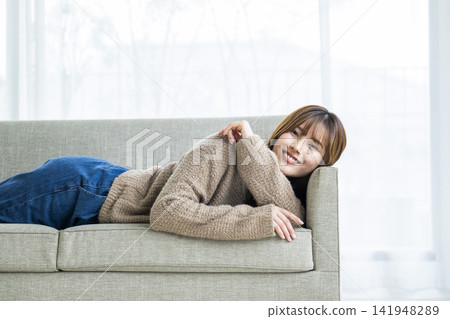 A young woman lying on a sofa A young woman lying on a sofa 141948289