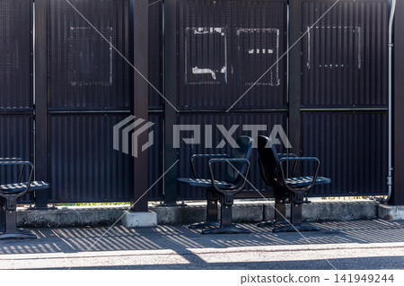 A deserted train platform, a silent scene of benches and shadows. A deserted train platform, a silent scene of benches and shadows. 141949244