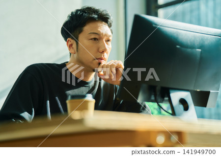 一個人在電腦上工作 一個人在電腦上工作 141949700