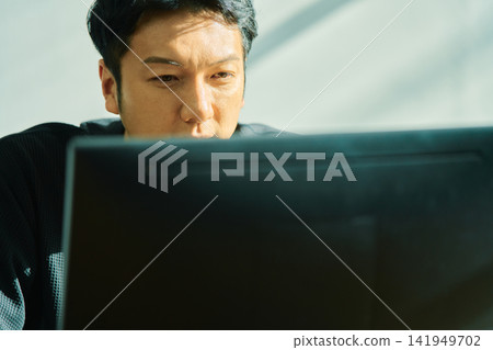 A man working on a computer A man working on a computer 141949702