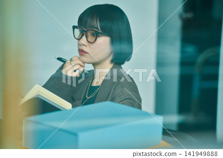 在辦公室工作的年輕女子 在辦公室工作的年輕女子 141949888