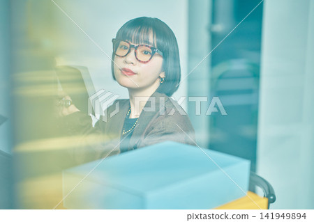 在辦公室工作的年輕女子 在辦公室工作的年輕女子 141949894