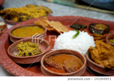 Traditional Bengali meal platter served in terracotta bowls with rice curry fish and side dishes Traditional Bengali meal platter served in terracotta bowls with rice curry fish and side dishes 141949951