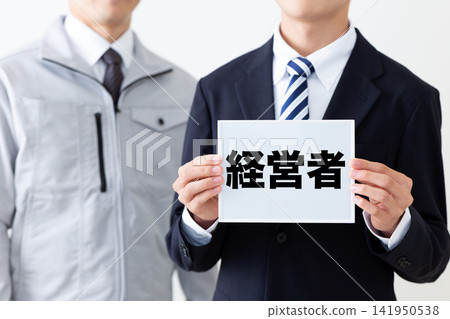 A young businessman in a business suit holding a whiteboard. A young businessman in a business suit holding a whiteboard. 141950538