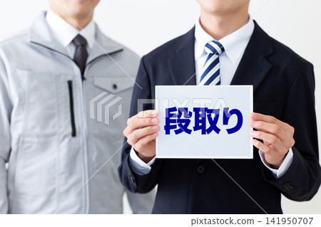 一位身穿西裝的年輕商人,手持一塊寫著日程安排的白板。 一位身穿西裝的年輕商人,手持一塊寫著日程安排的白板。 141950707