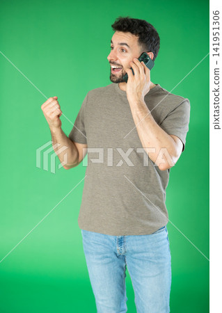 Adult man talking on mobile phone in front of green screen Adult man talking on mobile phone in front of green screen 141951306