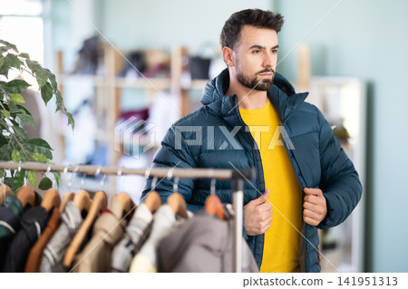 In store, man try on down jacket 141951313