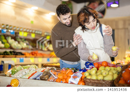 Couple shopping in vegetable store and buy elect pear Couple shopping in vegetable store and buy elect pear 141951436