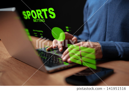 Person placing a sports bet online using a laptop with betting data displayed Person placing a sports bet online using a laptop with betting data displayed 141951516