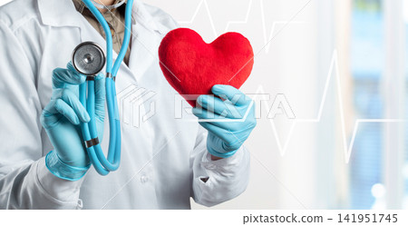 Health professional holds red heart symbol with stethoscope in hand in clinic Health professional holds red heart symbol with stethoscope in hand in clinic 141951745
