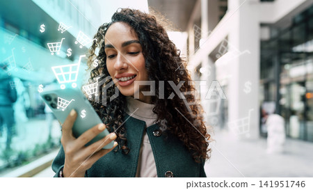 Woman using smartphone for online shopping in a mall during daytime Woman using smartphone for online shopping in a mall during daytime 141951746