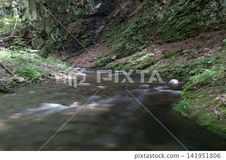 The Aiki River flows through the summer, surrounded by rugged rock faces and lush greenery. The Aiki River flows through the summer, surrounded by rugged rock faces and lush greenery. 141951806