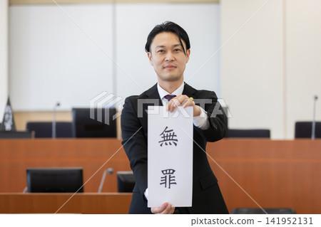 Japanese lawyer holds up "not guilty" document in court Japanese lawyer holds up "not guilty" document in court 141952131
