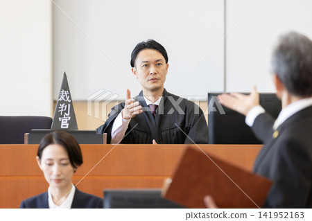 一位年輕的男法官正在法庭上主持審判。 141952163