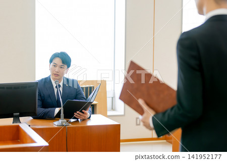 檢察官在法庭上旁聽辯護律師的辯論。 檢察官在法庭上旁聽辯護律師的辯論。 141952177
