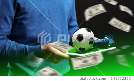 Sport betting activity with money and soccer items taking place indoors Sport betting activity with money and soccer items taking place indoors 141952233