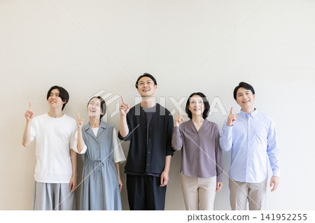 A group of Japanese men and women pointing upwards to indicate the future or their ideas. A group of Japanese men and women pointing upwards to indicate the future or their ideas. 141952255