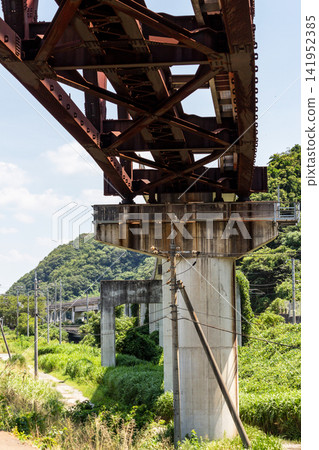 A view of the railway bridge's truss structure and concrete piers from below. A view of the railway bridge's truss structure and concrete piers from below. 141952385