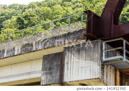 Close-up of a railway bridge and bridge piers running through a mountainous area. Close-up of a railway bridge and bridge piers running through a mountainous area. 141952392