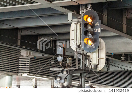 Railway signal within the station premises (caution signal, two yellow lights illuminated) Railway signal within the station premises (caution signal, two yellow lights illuminated) 141952419