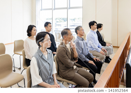 People of various generations watching the trial from the courtroom gallery. People of various generations watching the trial from the courtroom gallery. 141952564