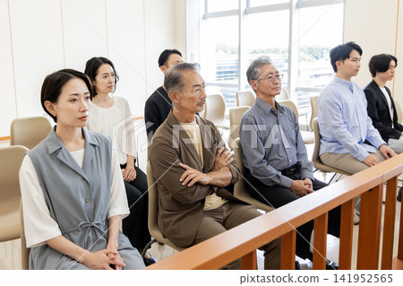 People of various generations watching the trial from the courtroom gallery. People of various generations watching the trial from the courtroom gallery. 141952565