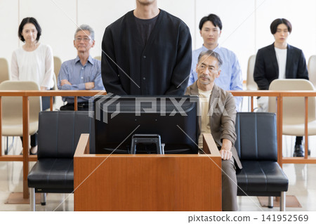 A young man testifying in court and spectators watching the trial. A young man testifying in court and spectators watching the trial. 141952569