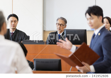 A judge listening to arguments in court and the proceedings A judge listening to arguments in court and the proceedings 141952606