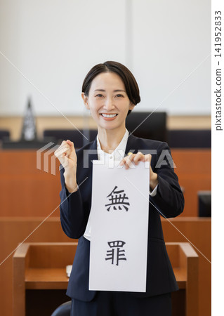 一名女律師在法庭上舉起一份「無罪」文件,並做出勝利的手勢。 一名女律師在法庭上舉起一份「無罪」文件,並做出勝利的手勢。 141952833