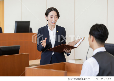 一名女律師在法庭上盤問證人。 一名女律師在法庭上盤問證人。 141952856