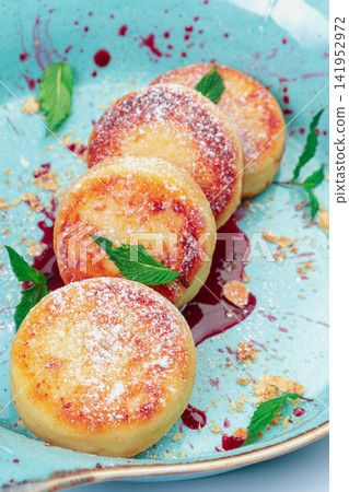 Fried cottage cheese pancakes with powdered sugar on plate Fried cottage cheese pancakes with powdered sugar on plate 141952972
